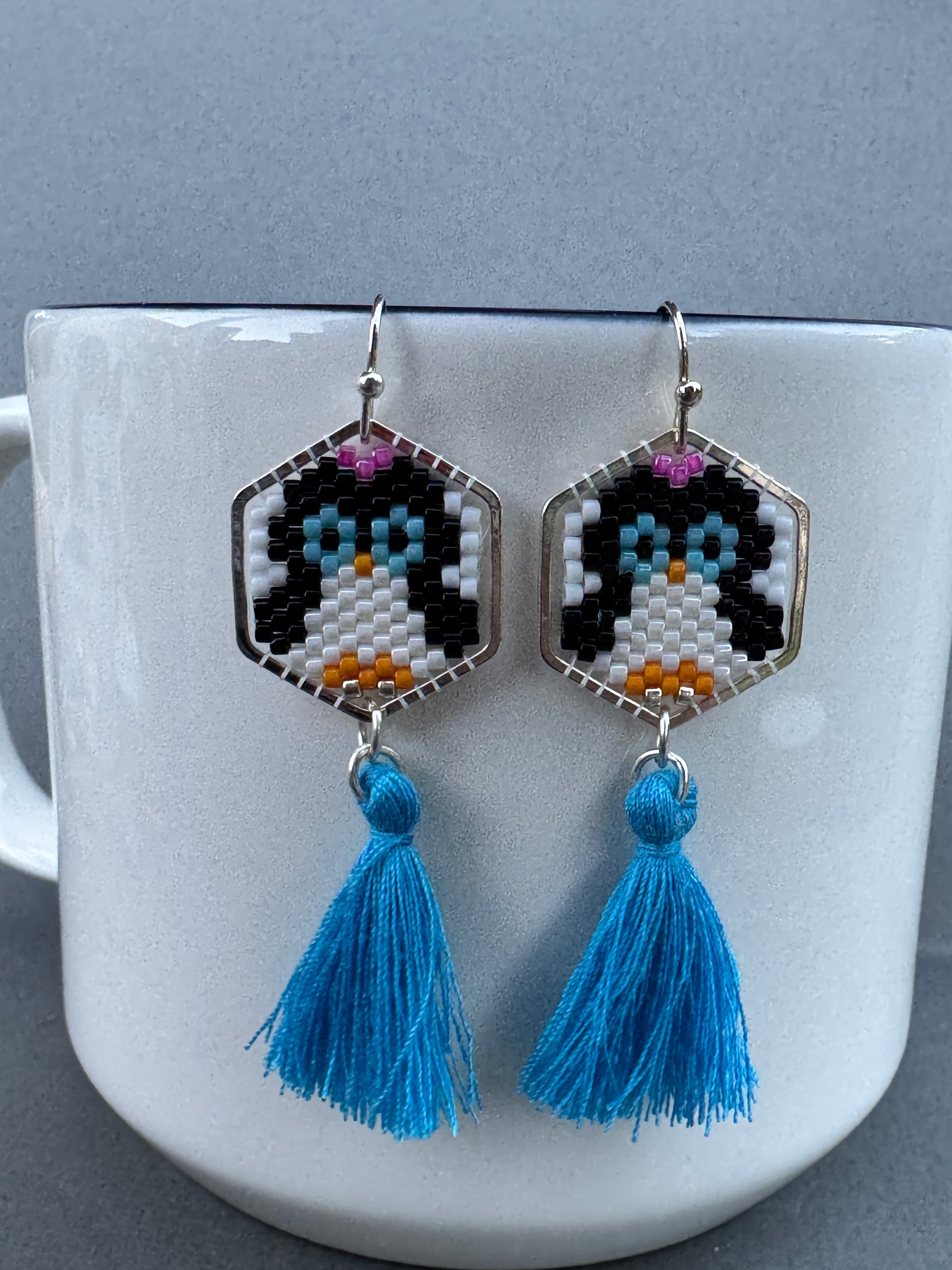 Beaded penguin earrings in silver-plated hexagon frames with bright blue tassels and silver-plated hooks
