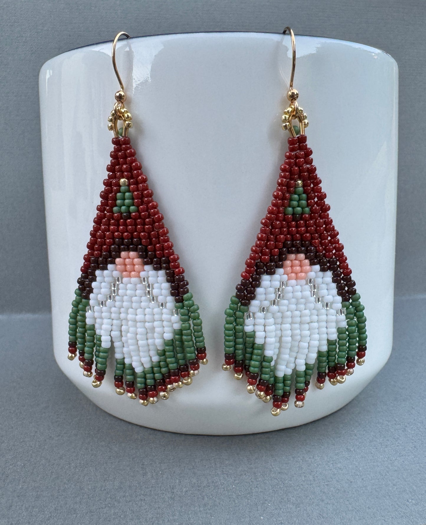 Beaded Santa gnome fringe earrings featuring red hats, white beards, green trim, and gold-plated ear wires