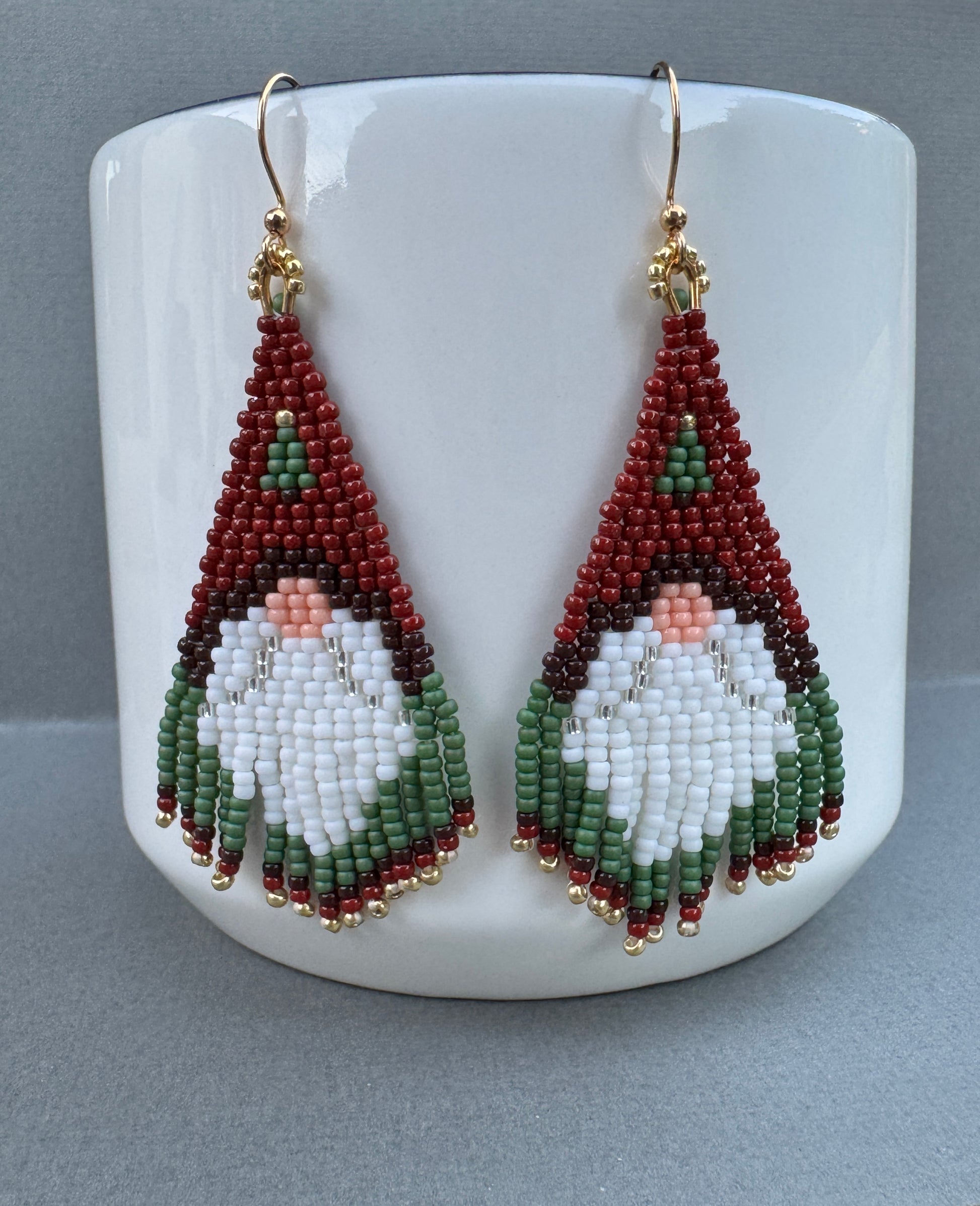 Beaded Santa gnome fringe earrings featuring red hats, white beards, green trim, and gold-plated ear wires