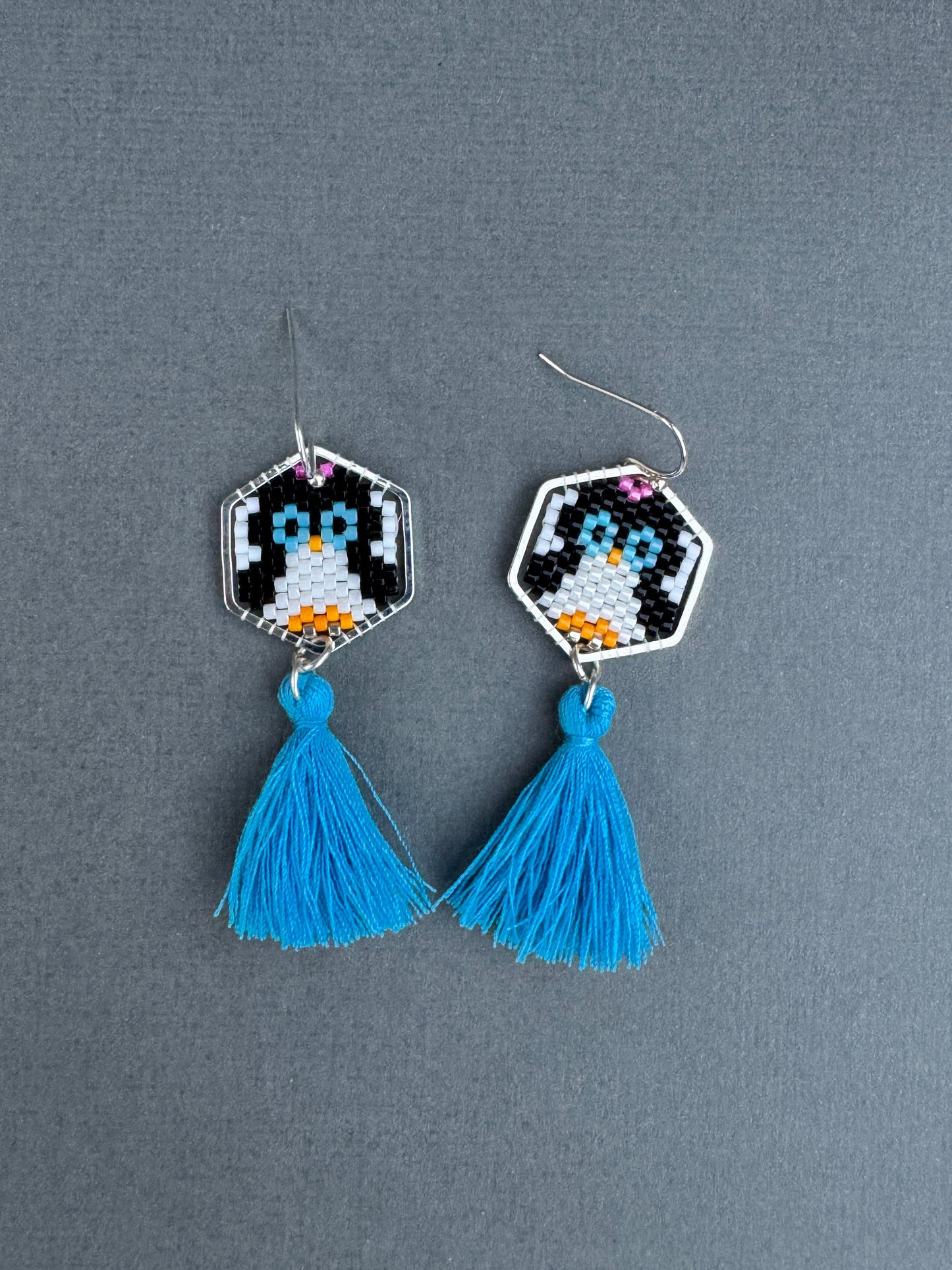Hand-beaded penguin tassel earrings with blue cotton tassels and silver-plated hexagon frames